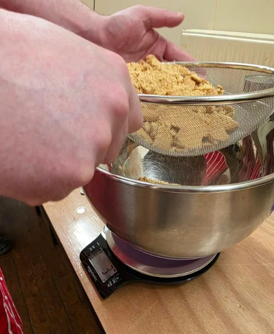 Sifting ingredients over a mixing bowl at The Preshal Trust Paisley